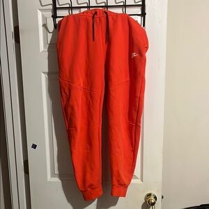 Red Nike tech pants